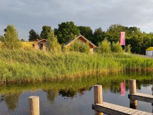 Bootssteg mit Blick auf die Ferienhäuser am See