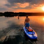 Camper kneeing on the SUP beautiful evening light