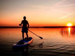 Mann im Gegenlicht beim SUP Fahren an der Goitzsche